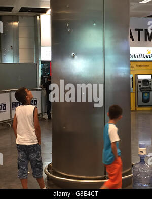 Istanbul, Türkei. 29. Juni 2016. Zwei Jungen schauen Einschusslöcher in eine Säule auf dem Atatürk-Flughafen in Istanbul, Türkei, 29. Juni 2016. Mindestens 36 Menschen getötet und mehr als 140 andere wurden verletzt in drei separate Waffe und Bombe Angriffe innerhalb und außerhalb von Istanbul Atatürk Flughafen-Terminal am 28. Juni, Medien berichteten Beamte zu zitieren. Foto: Mirjam Schmitt/Dpa/Alamy Live News Stockfoto