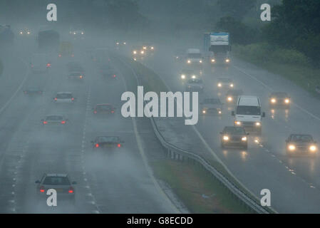 Starker Regen erzeugt auf der Autobahn M5 in der Nähe von Dursley, Gloucestershire, Sprühnebel, schlechte Sicht und wenig Licht. Stockfoto