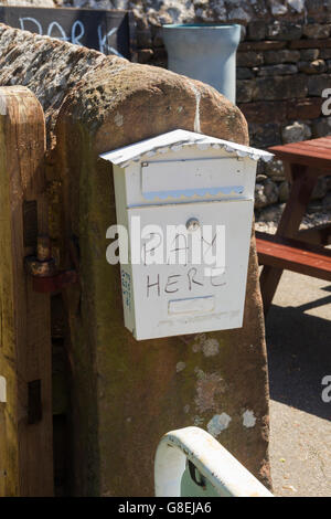 Ehrlichkeit-Box für unbeaufsichtigte Zahlungen für Parkplätze auf eine inoffizielle Parkplatz an Pooley Bridge, Cumbria. Stockfoto