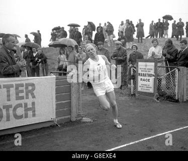 Basil Heatley von Coventry Godiva Harriers betritt das Chiswick-Stadion, um seine Endrunde zu machen und den Poly (Polytechnic) Marathon von Windsor nach Chiswick in der neuen Weltrekordzeit von 2 Stunden, 13 Minuten, 55 Sekunden zu gewinnen. Das Rennen wird im Zusammenhang mit dem Kinnaird Trophy Athletics Meeting durchgeführt. Stockfoto