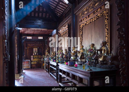 Bodhisattva Statuen beleuchtet mit einem Sonnenstrahl im Schrein am Vĩnh Tràng Mahayana Buddhist Temple, My Tho Village, Mekong Delta, Vietnam Stockfoto