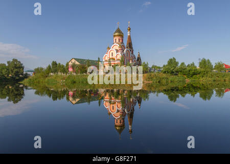 Russisch-orthodoxe Kirche in Almaty, Kasachstan, auch bekannt als Kirche der Erhöhung des Heiligen Kreuzes und dessen Spiegelbild im Wasser. Stockfoto