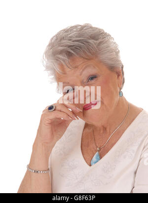 Eine schöne ältere Frau in den Siebzigern hielt ihre Hand auf ihr Gesicht und sah überrascht, für weißen Hintergrund isoliert. Stockfoto