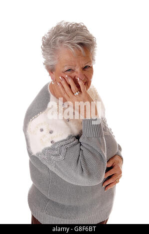 Eine ältere Senioren Frau isoliert für weißen Hintergrund hielt eine Hand auf ihr Gesicht und Lächeln auf den Lippen. Stockfoto