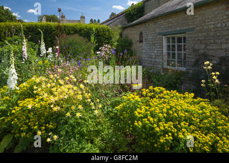 Bunte Häuschen Gartenblumen neben eine steinerne Gartenspeicher Easton Walled Garden in der Nähe von Grantham, Lincolnshire, England Stockfoto