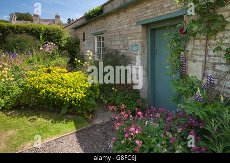 Bunte Häuschen Gartenblumen neben eine steinerne Gartenspeicher Easton Walled Garden in der Nähe von Grantham, Lincolnshire, England Stockfoto