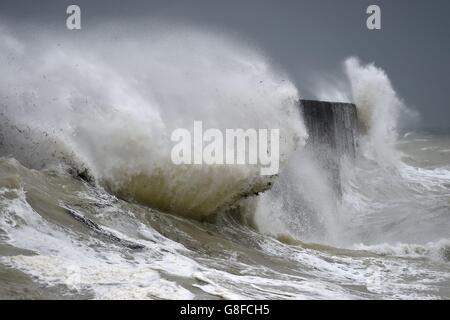 Wellen stürzen in den Wellenbrecher in Newhaven, East Sussex. Stockfoto