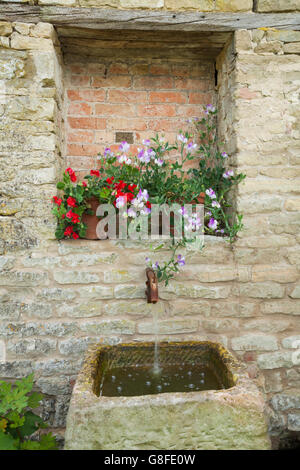 Blumentöpfe mit Zuckererbsen neben ein Wasserspiel im Garten von Easton Walled-Bauerngarten, Lincolnshire, England Stockfoto