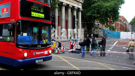 Ein Bus der Nummer 30 fährt am Freitag, dem 8. Juli 2005, am Woburn Place vorbei und die Bildschirme (rechts), die den Bus auf derselben Strecke abschirmen, die eines von vier Terrorzielen in der Hauptstadt am Donnerstag war. Scotland Yard hat bestätigt, dass bei den Anschlägen mindestens 37 Menschen ums Leben kamen und sagte, dass es 700 Opfer gab, von denen 300 mit dem Krankenwagen ins Krankenhaus gebracht wurden, aber eine Polizeiquelle sagte, dass die Zahl auf mindestens 41 Tote steigen würde. Stockfoto