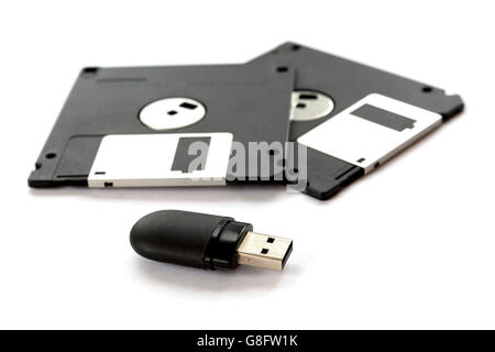 Zwei schwarze Disketten und ein Flash-Laufwerk auf einem weißen Hintergrund isoliert. Stockfoto
