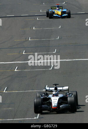 Kolumbiens Juan Pablo Montoya fährt mit dem McLaren Mercedes über die Linie vor dem spanischen Fernando Alonso im Renault (oben). Stockfoto