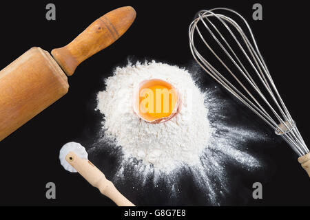 Schneebesen und Zutaten auf einem schwarzen Hintergrund Stockfoto