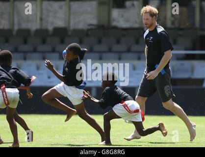 Prince Harry spielt Tag Rugby mit Kindern im Kings Park Stadium, während er sich mit Mitgliedern des Sharks Rugby Teams auf dem Spielfeld in Durban in einem Training und Skills Sessions mit Trainern und jungen Spielern im Rahmen seines Besuchs in Südafrika trifft. Stockfoto