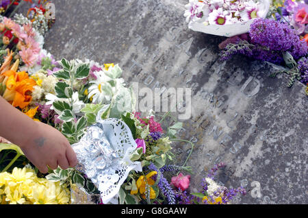 Kinder der Wilden All Saints School setzen eine jahrhundertealte Tradition fort, als sie Blumen am Grab eines cowman legten, der 1899 starb. Thomas Jones überließ seinen gesamten Besitz den Kindern des Dorfes unter der Bedingung, dass sie jedes Jahr an seinem Geburtstag, dem St.-Swithen-Tag, ein Lied sangen und Blumen über sein Grab im Worcestershire-Dorf Wilden legten. Stockfoto