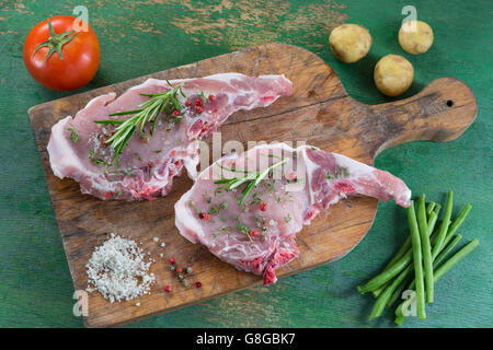 Fleisch-Schwein mit Kraut Petersilie isoliert auf Holzbrett Stockfoto