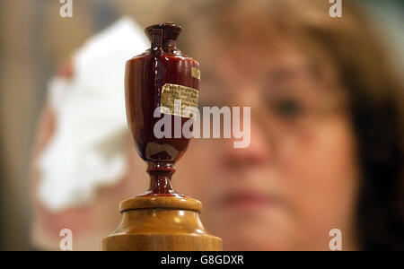 Glenys Williams, stellvertretender Kurator, reinigt das Glasgehäuse, das die Aschendrüse im Museum am Lords Cricket Ground, St John's Wood zeigt. Die Urne der Asche ist seit ihrer Präsentation durch Lord Darnleys in Australien geborene Witwe Florence ein Bestandteil des Lord's Museum. Stockfoto