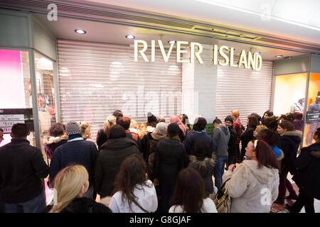 Während die Verkäufe am zweiten Weihnachtsfeiertag beginnen, warten die Käufer darauf, in ein River Island-Geschäft im Londoner Einkaufszentrum Brent Cross einzusteigen. Stockfoto