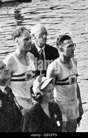 Die Goldmedaillengewinnerinnen Bertie Bushnell (l) und Richard Burnell (r), Großbritanniens, sind beim Spielen der Nationalhymne sehr aufmerksam Stockfoto