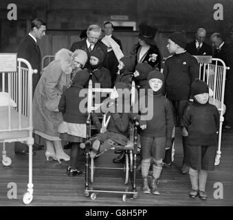 Der Herzog und die Herzogin von York unterhalten sich mit Patienten neben dem Kinderbett der Prinzessin Elizabeth während der Eröffnung des Crippled Children's Hospital in Exeter. Stockfoto