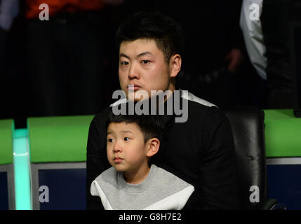 Liang Wenbo sitzt mit seinem Sohn Liang Chen, nachdem er das Endspiel gegen Neil Robertson am 12. Tag der 2015 Betway UK Snooker Championship beim York Barbican, York, verloren hatte. Stockfoto