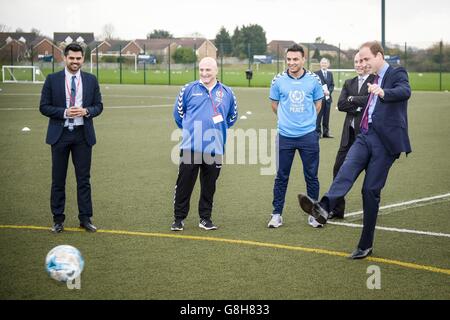 Der Herzog von Cambridge (rechts) verhängt eine Strafe gegen den 13-jährigen Torhüter Dominik Rynkar, als er bei einem Besuch der Saltley Academy in Birmingham Football for Peace-Botschafter traf. Stockfoto