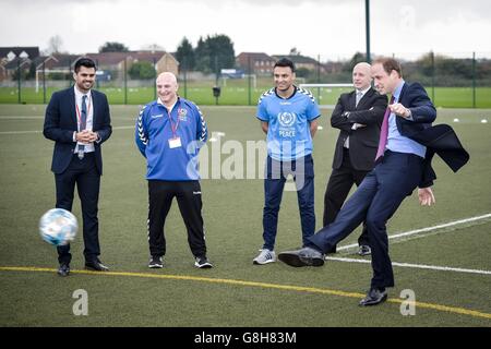 Der Herzog von Cambridge (rechts) verhängt eine Strafe gegen den 13-jährigen Torhüter Dominik Rynkar, als er bei einem Besuch der Saltley Academy in Birmingham Football for Peace-Botschafter traf. Stockfoto