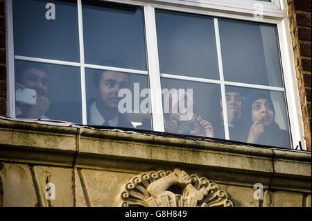 Schüler beobachten aus einem Fenster, wie der Herzog von Cambridge die Saltley Academy in Birmingham besucht, wo er Botschafter der Football for Peace-Initiative traf. Stockfoto