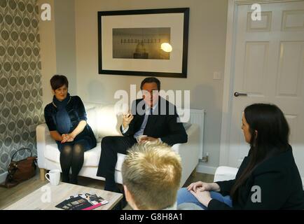 Premierminister David Cameron sprach mit den Hausbesitzern Jayne Sullivan (links) Gemma Hayes (rechts) und Nelson Mansfield bei einem Besuch der Orbit Homes-Entwicklung in Burton upon Trent. Stockfoto