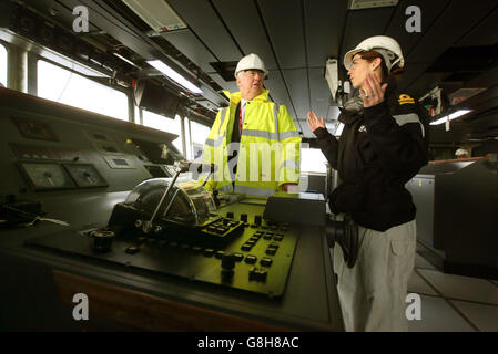 Verteidigungsminister Michael Fallon spricht mit der Vizenavigatorin der Royal Navy, Rachel Campbell, auf der Brücke des Flugzeugträgers HMS Queen Elizabeth, der derzeit im Bau in den Docks von Rosyth, Fife, ist. Stockfoto