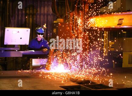 Ein Brenner verwendet einen Plasmaschneider, um Stahlplatten an Watson Towers in Coatbridge zu schneiden, um in die spezifischen Komponenten zu schneiden, die das Ende des Fachwerks auf der Forth Road Bridge fixieren. Stockfoto