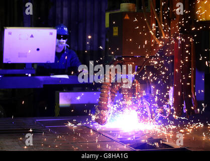 Ein Brenner verwendet einen Plasmaschneider, um Stahlplatten an Watson Towers in Coatbridge zu schneiden, um in die spezifischen Komponenten zu schneiden, die das Ende des Fachwerks auf der Forth Road Bridge fixieren. Stockfoto