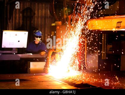 Ein Brenner verwendet einen Plasmaschneider, um Stahlplatten an Watson Towers in Coatbridge zu schneiden, um in die spezifischen Komponenten zu schneiden, die das Ende des Fachwerks auf der Forth Road Bridge fixieren. Stockfoto