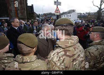 Der Prinz von Wales trifft sich mit Mitgliedern der Streitkräfte, während er Bewohner und Unternehmen auf der Bridge Street in Appleby-in-Westmorland, Cumbria, besucht, wo Schäden während der Überschwemmungen Anfang des Monats aufgetreten sind. Stockfoto