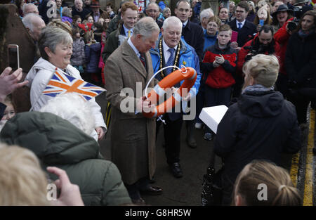 Der Prinz von Wales trifft sich mit Mitgliedern der Streitkräfte, während er Bewohner und Unternehmen auf der Bridge Street in Appleby-in-Westmorland, Cumbria, besucht, wo Schäden während der Überschwemmungen Anfang des Monats aufgetreten sind. Stockfoto