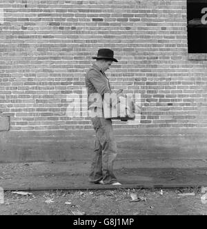 Cotton Picker tragen Farm Security Administration (FSA) Grant of Food und Notwendigkeiten, zu seiner Familie im FSA Migrant Camp, Bakersfield, Kalifornien, USA, Dorothea Lange für Farm Security Administration, November 1938 Stockfoto