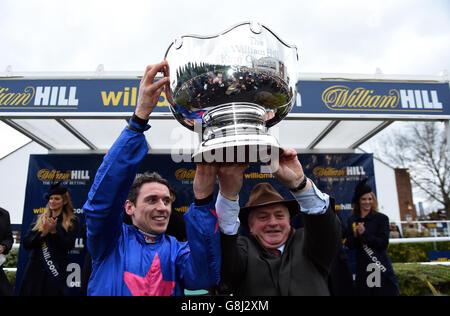 Jockey Paddy Brennan (links) und Trainer Colin Tizzard feiern mit der Trophäe, nachdem sie die King George VI Kirchturm-Verfolgungsjagd mit Cue Card am ersten Tag des William Hill Winter Festivals auf der Kempton Park Racecourse, Middlesex, gewonnen haben. Stockfoto