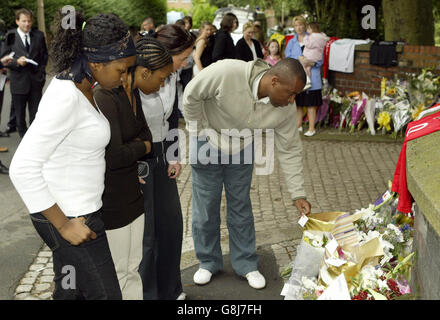 Mitglieder von Anthony Walkers Familie schauen sich Blumengebete an, die in der Nähe des Todespunktes des Teenagers zurückgelassen wurden. Stockfoto