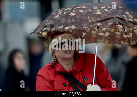 Pferderennen - Lincoln Family Fun Day - Doncaster Racecourse. Ein Rennfahrer untersteht einem Regenschirm auf den Tribünen Stockfoto