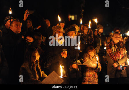 Mitglieder der Öffentlichkeit halten brennende Fackeln fest, während sie sich im Vaughan Millennium Apple Orchard während einer 'Wassail' in Hartley Wintney, Hampshire, versammeln. Stockfoto