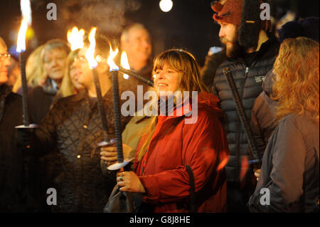 Mitglieder der Öffentlichkeit halten brennende Fackeln fest, während sie sich vor dem Wagon und den Pferden versammeln, bevor sie während einer „Wassail“ in Hartley Wintney, Hampshire, zum Vaughan Millennium Apple Orchard aufbrechen. Stockfoto