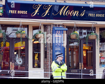 Ein Metropolitan Police Officer steht vor den Eingangstüren des J J Moon's Pub in Hornchurch, Essex, wo gestern Nachmittag ein 60-jähriger Mann erstochen wurde. Stockfoto