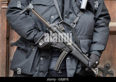 Vor den Houses of Parliament in London steht ein Waffenoffizier der Metropolitan Police, da die Zahl der bewaffneten Offiziere in Großbritanniens größter Polizei nach den Terroranschlägen in Paris um mehr als ein Viertel steigen wird. Stockfoto