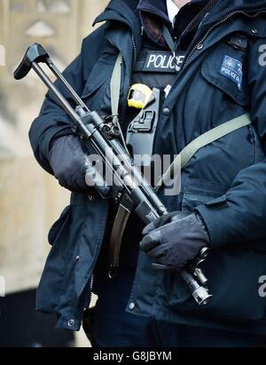 Vor den Houses of Parliament in London steht ein Waffenoffizier der Metropolitan Police, da die Zahl der bewaffneten Offiziere in Großbritanniens größter Polizei nach den Terroranschlägen in Paris um mehr als ein Viertel steigen wird. Stockfoto