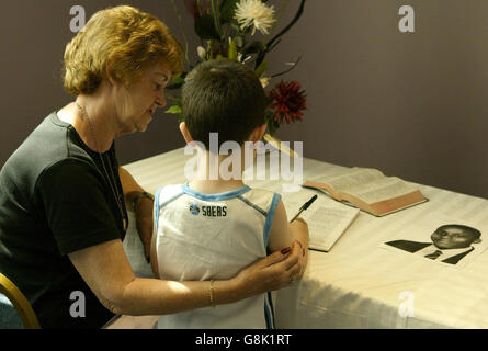 MEG McMahon und ihr Enkel Matthew Heneghan unterzeichnen in der Kirche des ermordeten Teenagers Anthony Walker, der Grace Family Church, in Aigburth ein Kondolenzbuch. Stockfoto