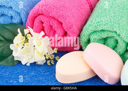 Bunte Handtücher mit Blumen und Seifen Nahaufnahme Bild gerollt. Stockfoto