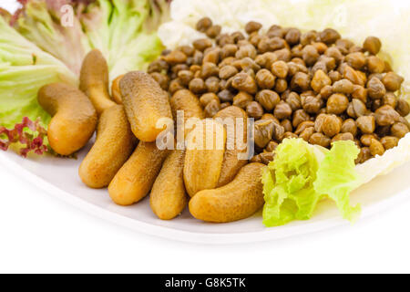 Marinierte Gurken, Kapern und Salat auf Teller. Stockfoto