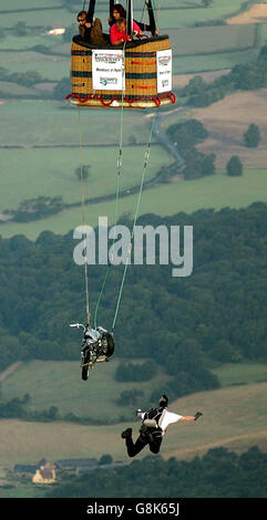 Ian Ashpole springt von seinem speziell angefertigten Chopper-Motorrad, das unter einem Heißluftballon aus einer Höhe von 3,000 Metern über Ashton Court schwebt. Stockfoto