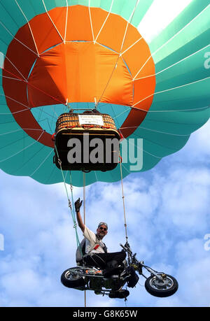 Ian Ashpole bereitet sich darauf vor, von seinem speziell angepassten Chopper-Motorrad zu springen, das unter einem Heißluftballon aus einer Höhe von 3,000 Fuß über Ashton Court aufgehängt wird. Stockfoto