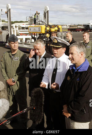 (Von links nach rechts) Keith Hewitt, der Anführer der RAF-Geschwader, Adam Ingram (M.P.) und Ian Riches, der Kommandant der Royal Navy, mit Stuart Gold (rechts - Scorpio 45, der Teamleiter des ferngesteuerten Fahrzeugs) sprechen nach der Ankunft am Flughafen Prestwick mit den Medien. Mit dem Rest des Rettungsteams, nachdem sie die sieben russischen Matrosen, die in ihrem U-Boot vom Grund des Pazifischen Ozeans gefangen waren, erfolgreich gerettet hatten. Das 29-köpfige britische Team, das mit einem lebensrettenden ferngesteuerten Rettungsfahrzeug aus Schottland geflogen war, schaffte es am Sonntag, ihn zu lockern. Stockfoto