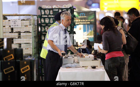 Passagiere im Terminal 4 des Flughafens Heathrow erhalten vor dem Abflug auf ihren Flügen Lebensmittelpakete, die von der Catering-Gesellschaft von Gate Gourmet BA abgespreist werden. Gate Gourmet hat gestern in Folge 500 seiner Beschäftigten wegen der Pläne zur Umstrukturierung der Arbeitspraktiken entlassen. Das Unternehmen behauptete, dass die Arbeiter einen inoffiziellen Streik ausübten, aber die Gewerkschaft Transport und General Workers Union beschuldigte Manager, den Streit absichtlich provoziert zu haben. Stockfoto